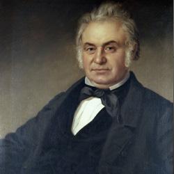 Portrait of an older man with gray hair, sideburns, a dark suit, white shirt, and black bow tie.