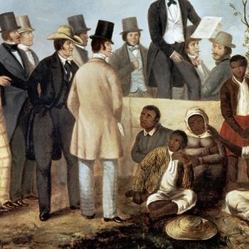 A group of men in formal clothing stand while Black people sit on the ground, some appearing distressed.