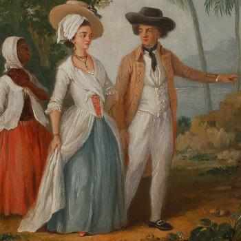 Three people in historical attire walk outdoors; a man points ahead, a woman walks beside him, and another follows.