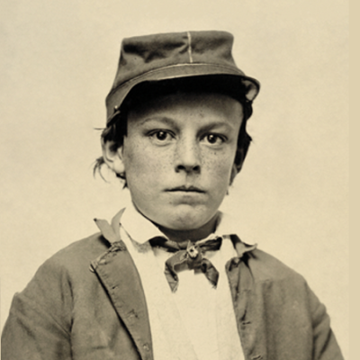 Sepia-toned portrait of a boy in old-fashioned clothing and cap, looking seriously at the camera.