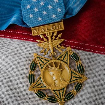 A gold Medal of Honor with a blue ribbon